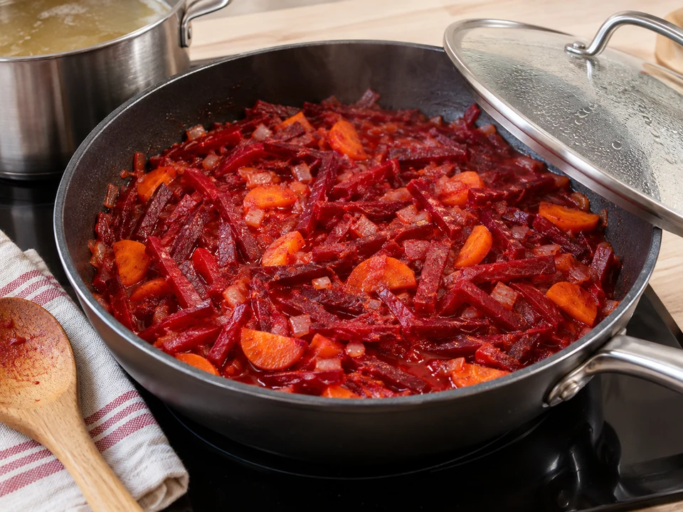 Rote Bete mit Zwiebel, Möhre und etwas Fleischbrühe vorgaren.