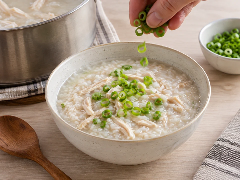 Congee mit den grünen Frühlingszwiebelringen anrichten.
